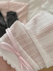Close-up detail of white ribbed knit socks with cute pink ribbon bow for sweet JK style.