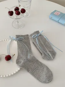 Grey Japanese style mid-tube socks with sweet blue ribbon bows, cute ruffled lace design.