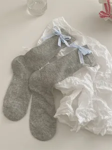 Detail shot of grey Japanese mid-calf socks featuring cute blue checkered bows for women.