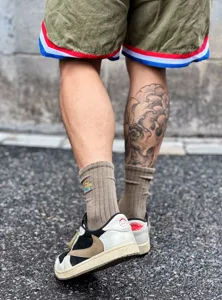 Vue détaillée de chaussettes en coton côtelé stylées avec broderie colorée pour look streetwear.