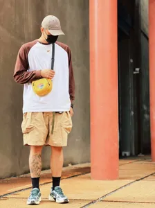 Détail de tenue streetwear style cityboy avec t-shirt manches longues et short.