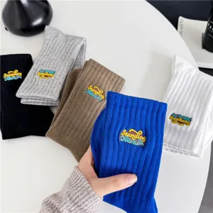 Chaussettes mi-hautes en coton confortables avec broderie stylée, idéales pour sport décontracté.
