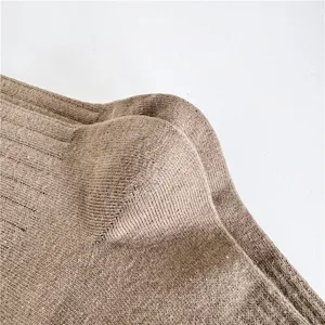 Gros plan détaillé du talon de chaussette en coton marron, texture tricotée douce et finition.