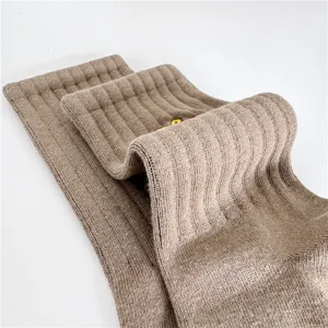 Gros plan détaillé de chaussettes en coton côtelé marron avec broderie délicate, douces.