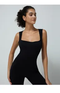 Detailed view of black ribbed square neck yoga jumpsuit, seamless athletic activewear