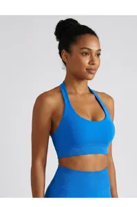 Detailed view of the bright blue halter sports bra showing neck and U-neck back support.