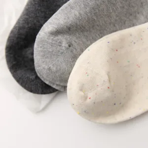 Dettaglio calzini donna in morbido cotone, con trama lavorata e vivaci puntini colorati.