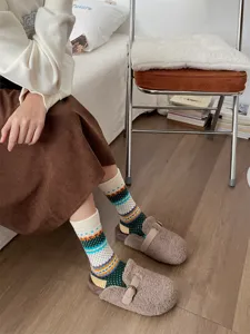 Gebreide sokken met jacquard patroon gecombineerd met comfortabele fleece clogs in vintagestijl.