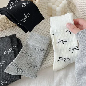 Close-up detail of cute bow print cotton mid-tube socks in multiple soft colors for daily wear.
