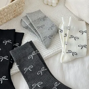 Close-up detail shot of womens mid-calf cotton socks featuring cute bow print patterns.