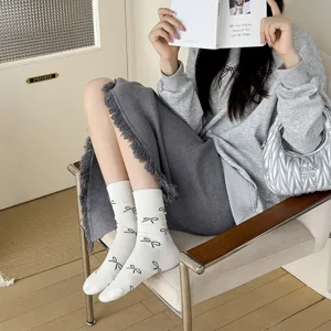 Korean style white crew socks with black bow print, vintage balletcore cotton socks detail.