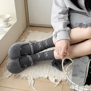 Grey bow mid-calf socks paired with vintage shoes, cozy lifestyle detail shot view.