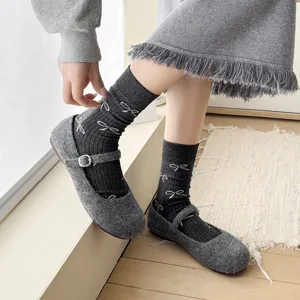 Grey bow mid-calf socks paired with retro felt Mary Jane shoes, detailed showcase of cute casual style.