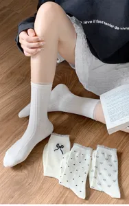 Nahaufnahme von japanischen Spitzen-Rüschen-Dauersocken mit Schleife, Punkten und Herzmustern.