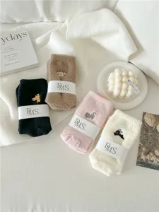Detalle de calcetines de invierno acogedores, tejido suave con bordados de animales lindos.
