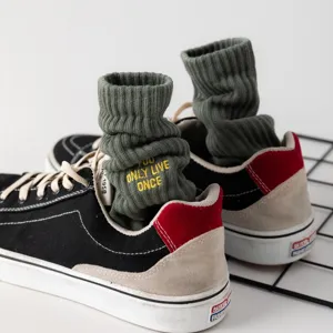 Grüne herren socken mit gelber stickerei buchstaben design, trendige streetwear socken.