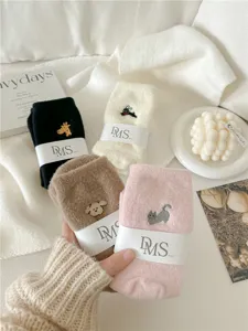 Detalle de calcetines de invierno mullidos y acogedores con bordado de animales tiernos, cálidos.