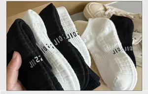 Detail view of black and white athletic towel socks, featuring soft ribbed texture and comfort.