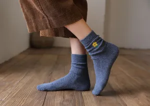 Vue détaillée de chaussettes en laine pour femmes avec broderie de fleurs jaunes et confort.