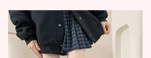 Détail de tenue veste style japonais et jupe à carreaux pour un look doux et tendance.