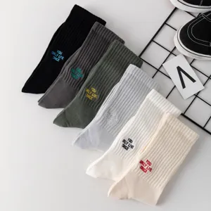 Detailaufnahme von Rippstrick-Socken mit gesticktem Slogan und bequemer Passform.