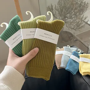 Nahaufnahme Detailansicht von bunten gerippten Mittelsocken mit Papierverpackungsetiketten.