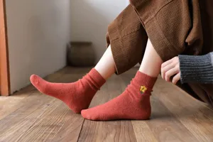Gros plan detail des chaussettes en laine chaudes pour femmes avec broderie florale 3D.