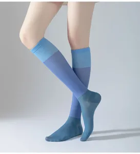 Chaussettes de sport de compression bleues, design long et respirant pour la course.