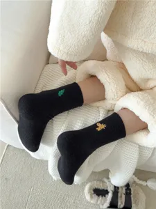 Detalle de suaves calcetines calentitos con bordado de animales para un gran invierno acogedor.