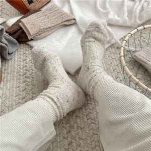 Close-up detail of women's thick warm speckled cable knit wool socks in cozy autumn style.