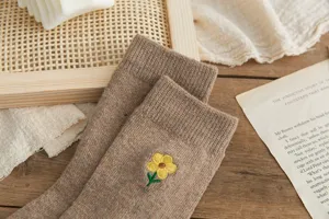 Chaussettes mi-mollet douillettes en laine marron avec jolies fleurs jaunes brodées pour femmes.