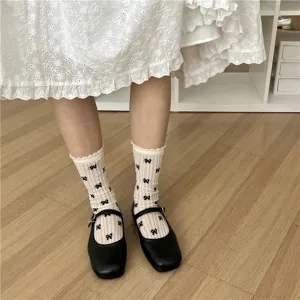 Detailed view of summer women's breathable mesh bow mid-calf socks paired with black shoes.