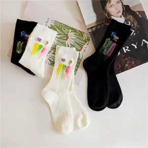 Vue détaillée de chaussettes mi-hautes femme avec éclaboussures d'encre et broderie, noir et blanc.