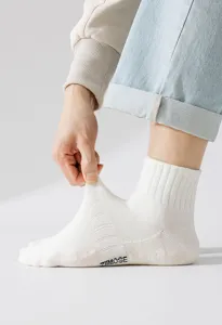 Men's white cotton athletic mid-calf socks detail showing elasticity and brand logo design.