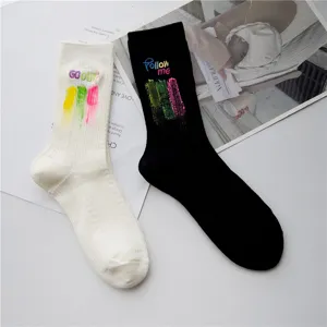 Chaussettes mi-hautes en coton avec lettres brodées et traits de pinceau colorés noir blanc.