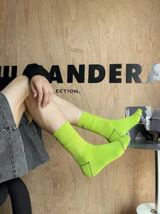 Green mid-calf athletic socks for men featuring ribbed cuffs and trendy embroidery details.