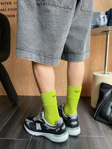 Men's bright green mid-calf athletic socks with ribbed cuffs and letter embroidery.