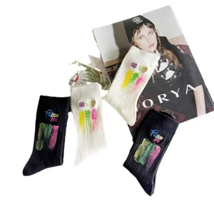 Chaussettes mi-hautes noires et blanches élégantes avec broderie et design d'encre colorée.