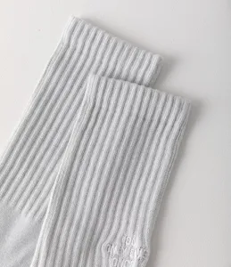 Graues geripptes Baumwollsocken-Detail, strukturierter Stoff, Nahaufnahme mit gesticktem Bündchen.