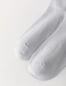 Nahaufnahme von hellgrauen Herren Socken, zeigt weiche Strickstruktur und nahtlose Zehenpartie.