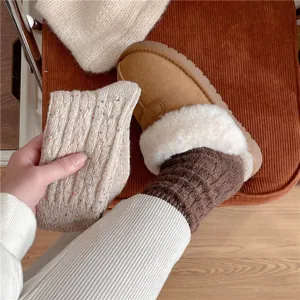 Close-up detail of cozy speckled yarn cable knit wool socks, soft warm winter texture.