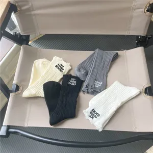 Vista dettagliata di calze in maglia da donna con lettere ricamate e design strappato alla moda.
