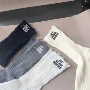 Set di calzini slouch strappati da donna in nero grigio bianco beige con ricamo alla moda.