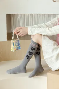 Chaussettes hautes grises avec motifs de cœurs noirs et rayures roses pour l'hiver.