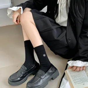 Eleganti calze al ginocchio nere in cotone da donna, con delicato ricamo di fiori bianchi.