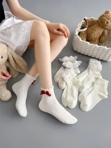 White lace ruffle mid-tube socks detail shot featuring cute red bow and knit pattern.