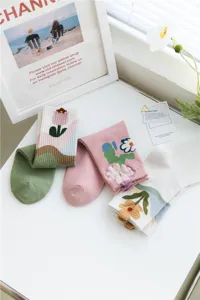 Detail view of Japanese style cute cream floral knit mid-calf socks for women, spring daily wear.
