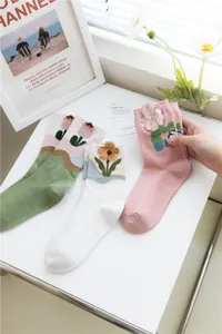 Detail shot of cute Japanese style crew socks featuring 3D plush flower embroidery for women.