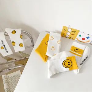 Jolies chaussettes montantes en coton blanc et jaune avec visage souriant et lettres pour femme.