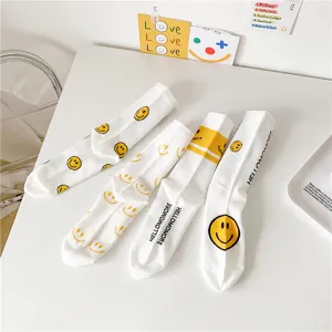 Chaussettes mi-mollet en coton blanc avec de mignons visages souriants jaunes et des lettres.